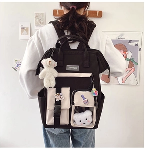Detail of canvas backpack featuring stylish contrast colors and a plush bear pendant