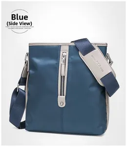 Detailed view of blue oxford fabric shoulder bag with vertical zipper and brand strap