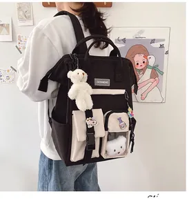 Detail view of large capacity school backpack with plush bear charm and contrast colors