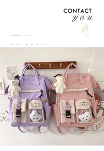 Close-up of purple and pink school backpacks with plush bear charm and clear pockets