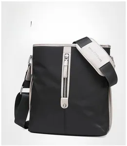 Detailed close-up of a black Oxford messenger bag featuring beige leather trim and a metal zipper