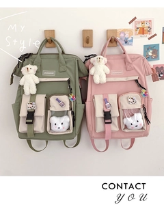 Detail of multi-pocket nylon backpack with transparent window and plush bear charm