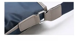 Detail of reinforced stitching and metal D-ring connection on blue Oxford fabric bag