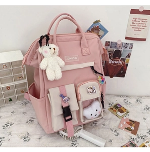 Detailed close-up of pink school backpack featuring multiple pockets and a cute bear charm