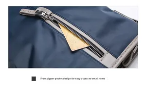 Close-up of the front zipper pocket on a blue Oxford fabric bag for small item storage