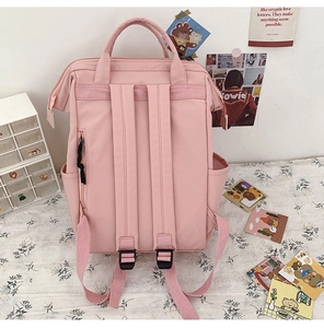 Pink nylon backpack rear view showing anti-theft zipper pocket and padded straps