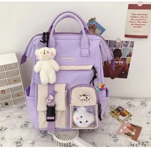 Close-up of lavender student backpack with cute badges, bear charm, and multi-pocket design