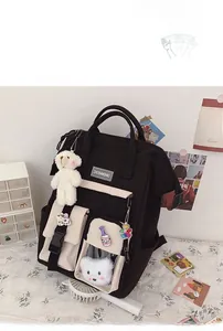 Detail view of large-capacity black and white backpack with plush bear charms and pockets