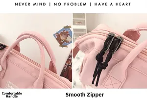 Detail of smooth double zippers and reinforced top handle on a pink nylon backpack