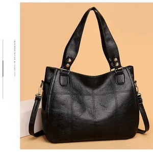 Detail of black PU leather tote bag featuring quilted texture and silver hardware