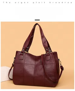 Macro shot of wine red trapezoid bag showing patchwork stitching and rivet details