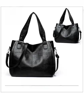 Detail view of large black tote bag with quilted stitching and silver hardware accents