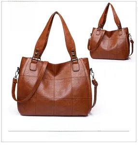 Detailed view of brown tote bag with quilted grid stitching and metal rivet handles