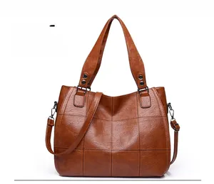 Detailed front view of brown PU leather handbag with elegant quilted stitching and straps