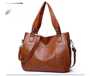 Brown quilted tote bag made of textured leather with dual handles and shoulder strap