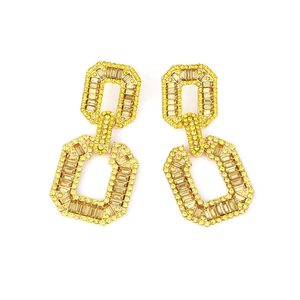 Macro shot of geometric double-ring earrings with yellow rhinestones and gold setting