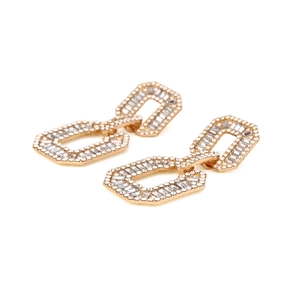 Macro detail of geometric alloy drop earrings with sparkling pavé-set rhinestones