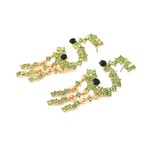 Gold snake tassel earrings with green rhinestones shown from an angled top view
