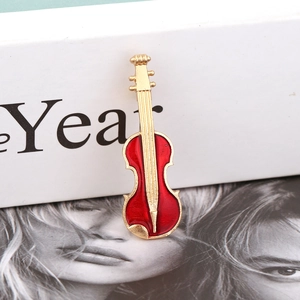 Broche violon élégante en émail rouge et placage doré présentée sur une boîte cadeau