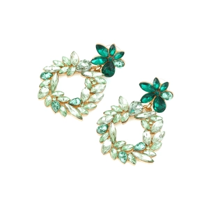 Macro shot of gold alloy flower earrings with green crystals in a wreath design