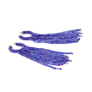 Détail de boucles d'oreilles faites main avec perles en dégradé bleu et violet style bohème