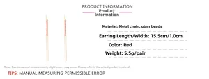 Vue détaillée des boucles d'oreilles pompon en perles rouges et chaîne dorée de 15,5 cm