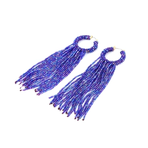 Détail macro de boucles d'oreilles bohèmes à franges perlées avec dégradé bleu et violet