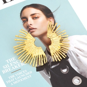 Detail of gold fan-shaped leaf earrings featuring unique sunburst textured alloy finish
