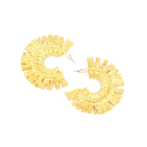 Boucles d'oreilles créoles dorées en alliage texturé avec motif rayonnant sur blanc