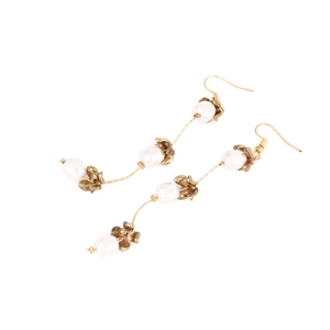 Close-up of elegant long pearl earrings with vintage gold flower petals and hooks