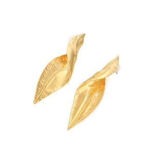Macro detail of gold-plated leaf earrings showing fine textured veins and crinkled design