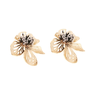 Macro detail of golden flower earrings with hollow petals and black beaded stamens