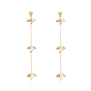 Long gold tassel earrings with delicate white floral accents and pearls in a minimalist style
