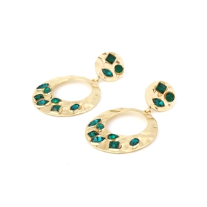 Detail von gold-gehämmerten Vintage-Ohrringen mit smaragdgrünen Kristallen auf Weiß
