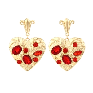 Luxurious gold heart earrings with red gemstones and hammered metal texture details