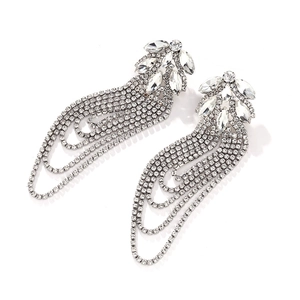 Close-up of silver tassel earrings with geometric crystals and flowing rhinestone fringe