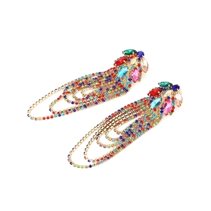 Macro shot of long tassel earrings with multicolored rhinestones and gold alloy base