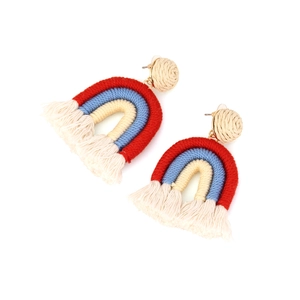 Detalle macro de pendientes arcoíris de cuerda de algodón tejida con flecos y pernos en espiral
