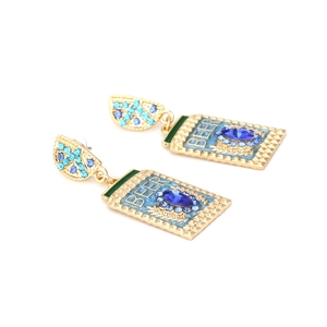 Detailed shot of golden beer bottle earrings with blue rhinestones and BEER engraving