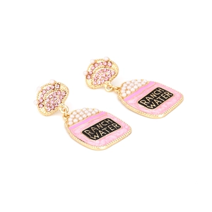 Détail macro des boucles d'oreilles thé au lait rose avec texte et perles élégantes
