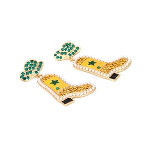 Detail of Western cowboy hat and boot earrings with yellow enamel and colorful rhinestones