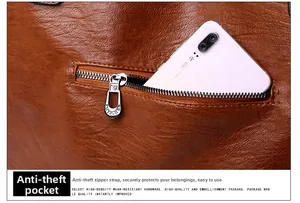 Detail of the anti-theft zipper pocket on large brown leather shoulder bag with a smartphone