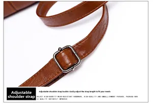 Macro view of brown leather adjustable shoulder strap with silver buckle detail