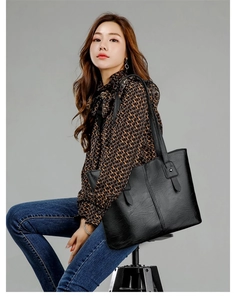 Gros plan du grand sac cabas noir avec texture grainée et détails de rivets métalliques