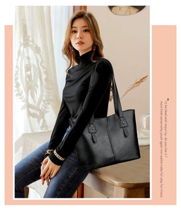 Gros plan d'un grand sac cabas noir en similicuir porté par un mannequin dans un intérieur