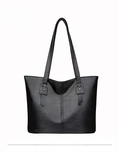 Vue avant du grand sac fourre-tout noir en PU avec texture litchi et détails de boucles