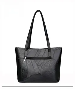 Vue détaillée du dos d'un grand sac cabas noir en patchwork avec une poche zippée pratique