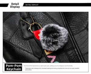Détail du sac cabas en cuir grainé noir avec pompon gris et sangle décorative lettrée