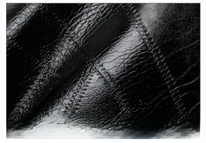 Vue macro du cuir noir brillant avec texture naturelle et détails de couture de haute qualité