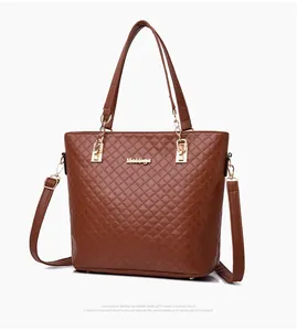 Détail d'un sac cabas marron matelassé avec finitions métalliques et logo de la marque